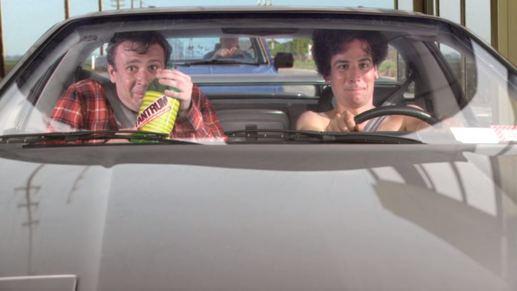 Scena z serialu "Jak poznałem waszą matkę". Młody Ted i Marshall siedzą w samochodzie i piją napój energetyczny Tantrum.