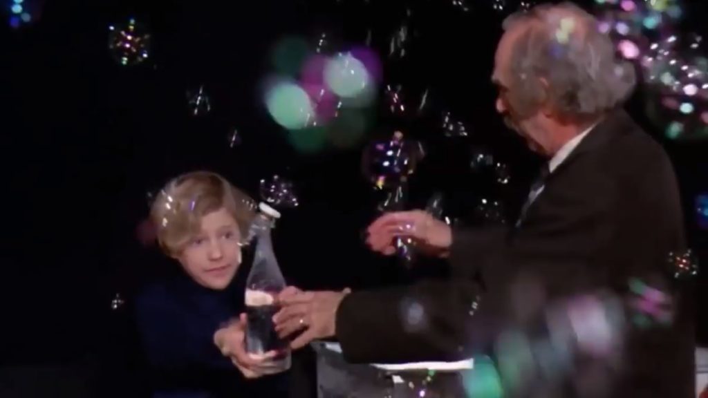 Scena z filmu "Willy Wonka i fabryka czekolady". Charlie i jego dziadek kosztują napoju unoszącego ich w górę.