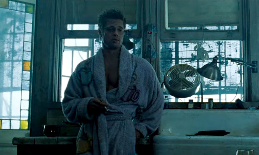 Kadr z filmu "Podziemny krąg". Mężczyna ubrany w gruby szlafrok opiera się o kuchenny blat.
